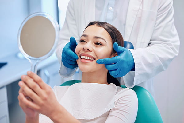 Image of a happy patient smiling at reflection in mirror. 